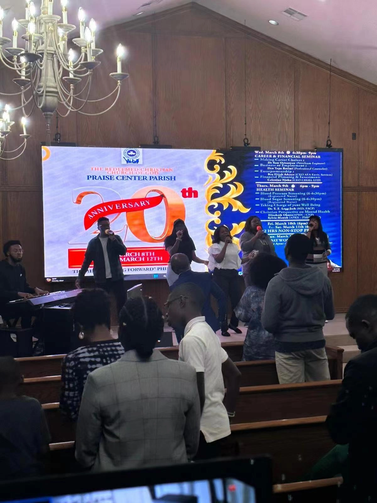 people sit in the church and sing a song with pastor