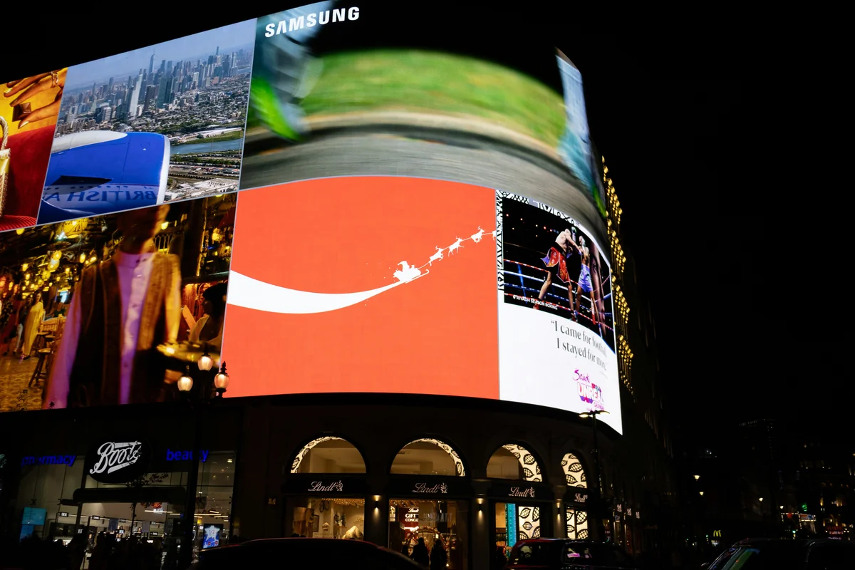 Bright billboards illuminate a city street at night. - giant led screen
