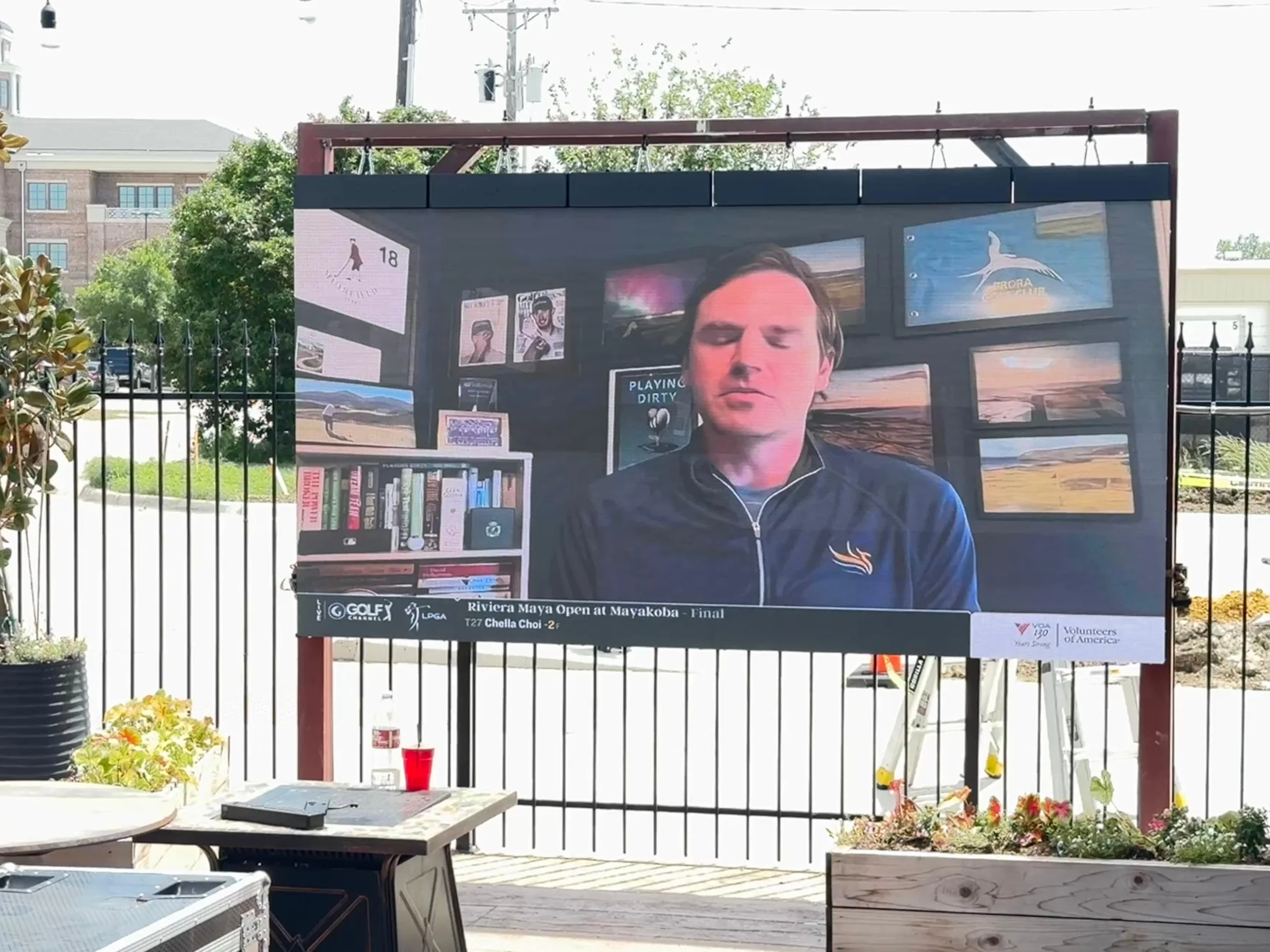 a led video wall hanging on the frame and set super close to the rest and drinking table