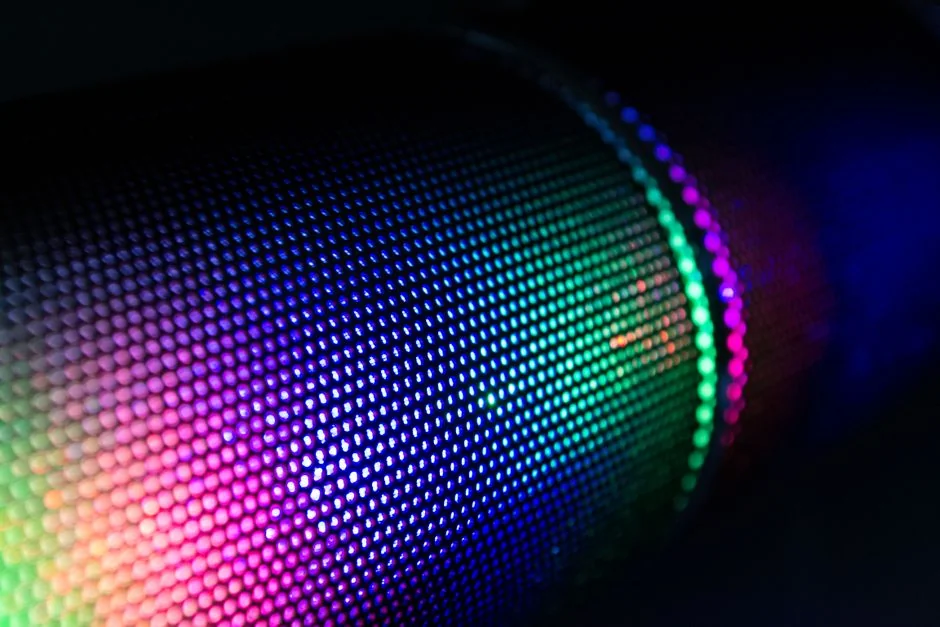 Close-up of a wireless speaker with colorful RGB lighting illuminating the mesh surface. - led color displays