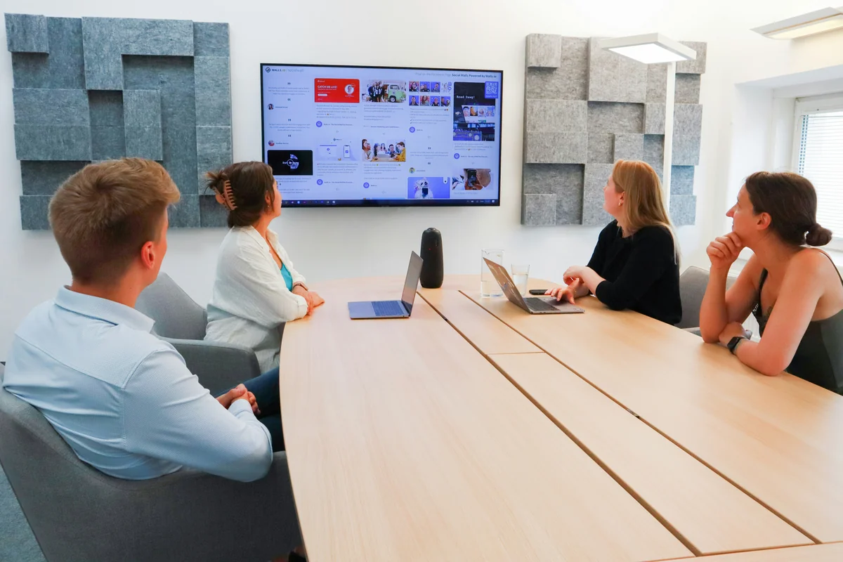 Team having a meeting in front of a screen - projection on wall vs screen